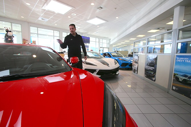 Cody Edwards, a Knudtsen Chevrolet salesman, walks by a red hot Chevy Corvette C8 Stingray in the Post Falls showroom.