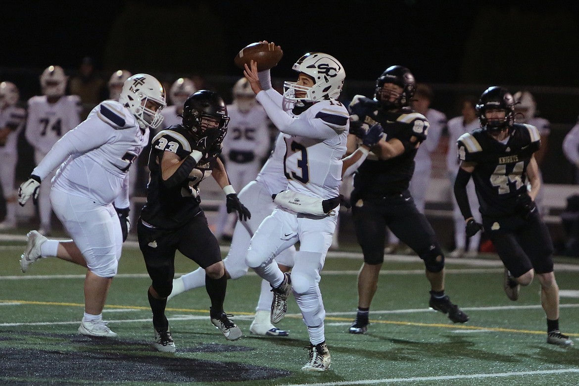 Royal senior Jared Lee (33) pressures Seton Catholic quarterback Kolten Gesser in the 1A state semifinals.