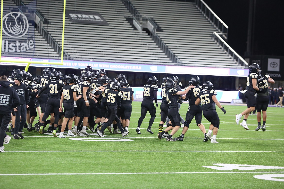 Royal players storm onto the field after winning their fourth straight state championship.