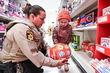 Brooklyn Amos picks out a toy with Paula Sullivan, a deputy and school resource officer with the Flathead County Sheriff's Office, during Shop With a Cop at Target in Kalispell on Wednesday, Dec. 13. (Casey Kreider/Daily Inter Lake)