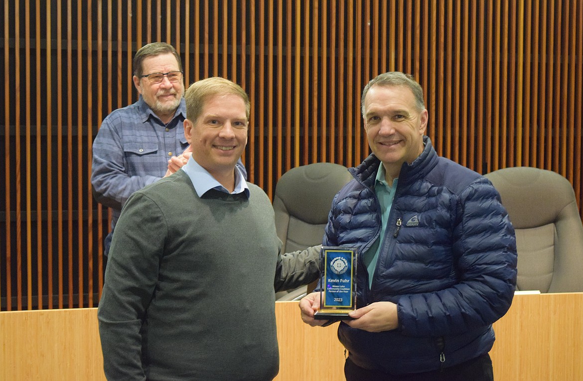 Moses Lake Community Coalition Vice Chair Matt Paluch, left, presents Moses Lake City Manager Kevin Fuhr, right, with the coalition’s 2023 Person of the Year award, which will be named after Fuhr moving forward.