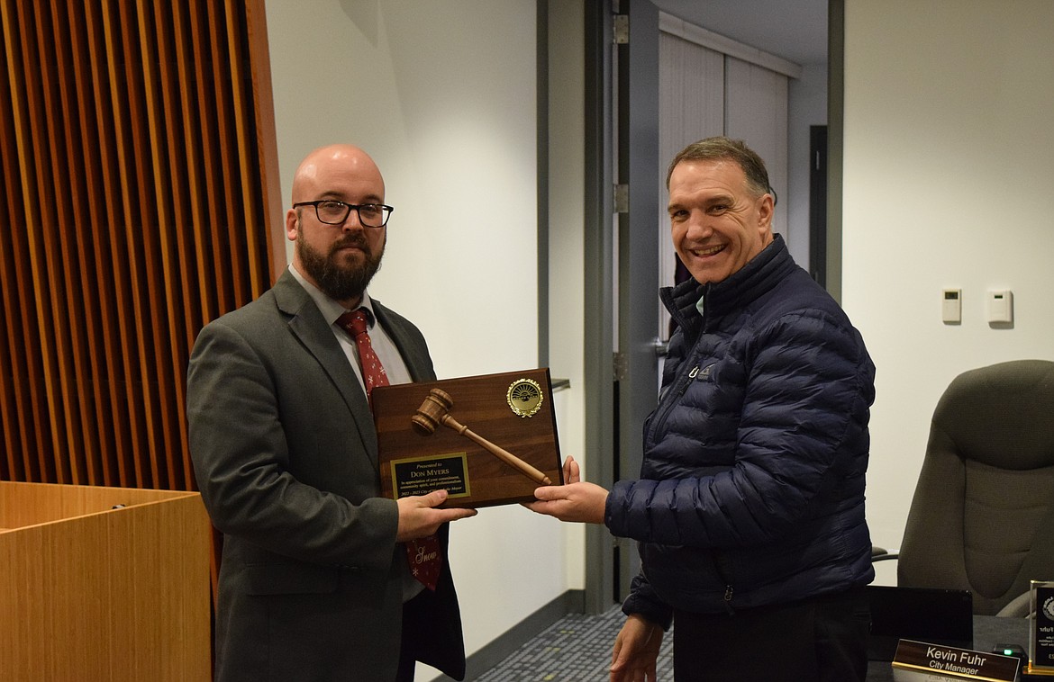 Moses Lake Mayor Don Myers, left, accepts a plaque recognizing his service as Mayor from City Manager Kevin Fuhr, right. Myers’ term on the council expires at the end of year, at which point he will join the council again as a council member.