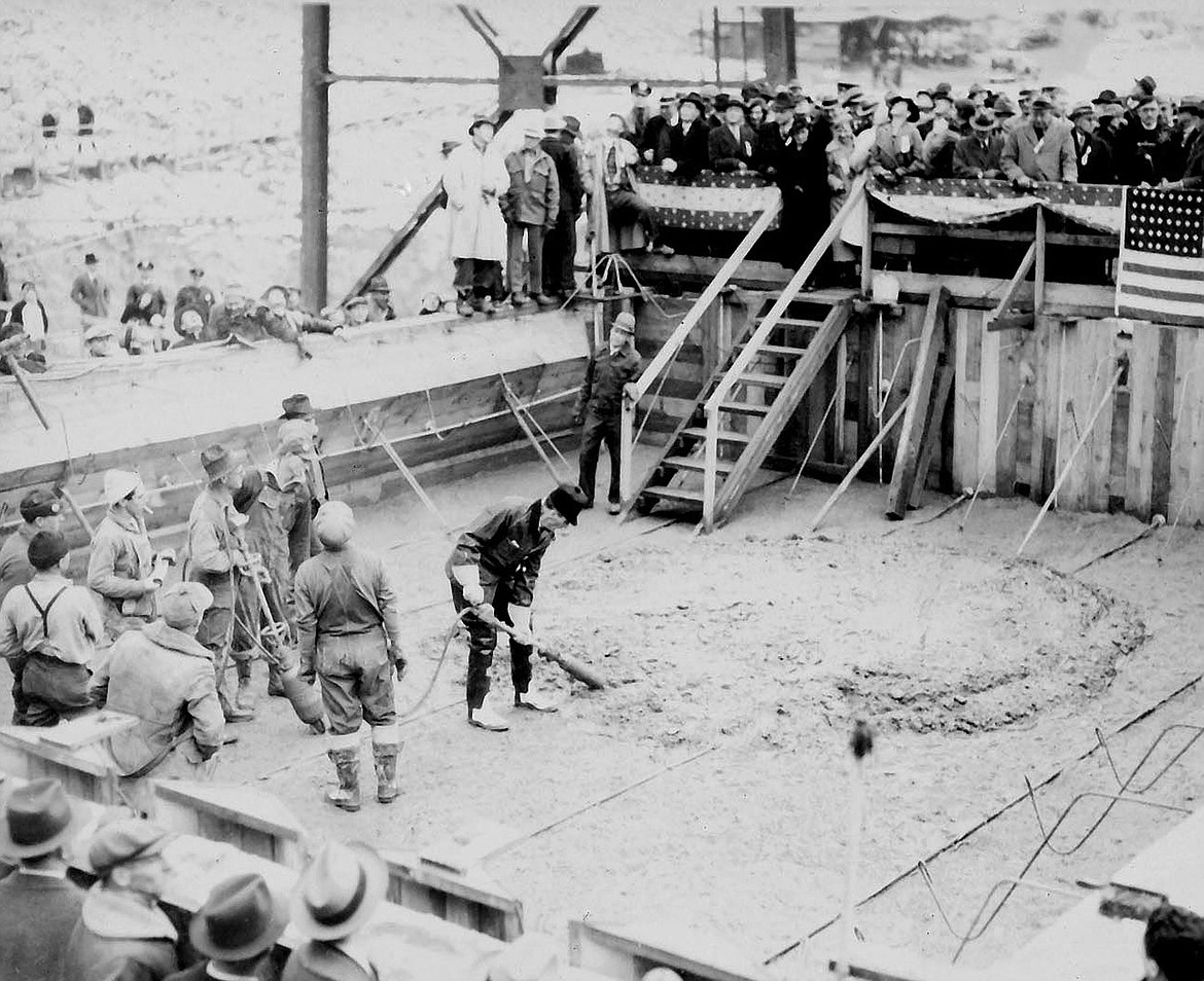 Washington Governor Clarence Martin donned coveralls and boots to work the ceremonial first pour of concrete at Grand Coulee Dam in December 1935.