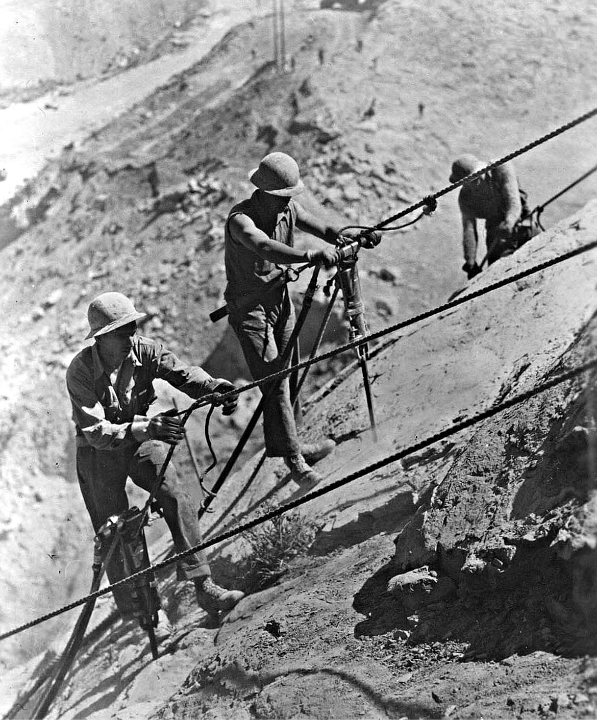 Workers drill blasting holes to remove rock from the site of Grand Coulee Dam in 1938.