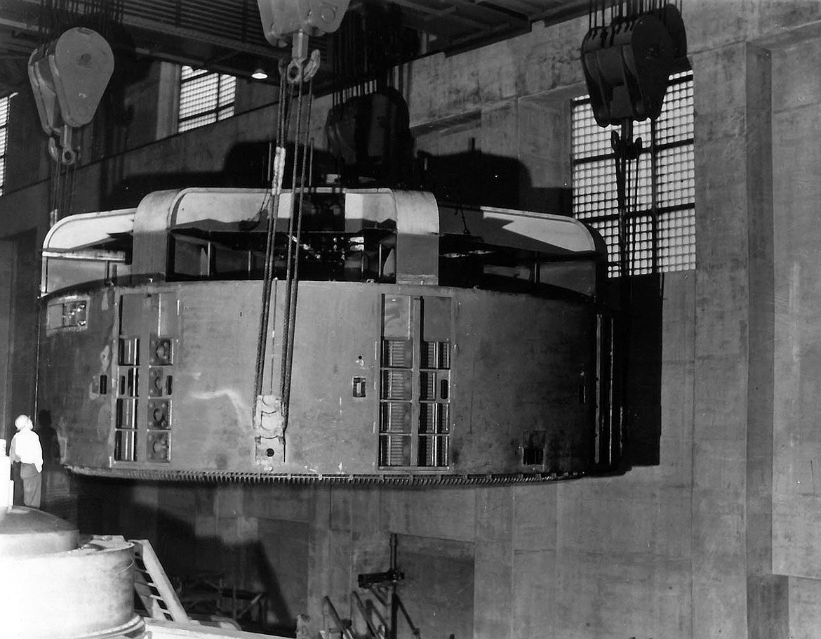 A turbine-generator component in the west powerhouse is moved into position in 1947,