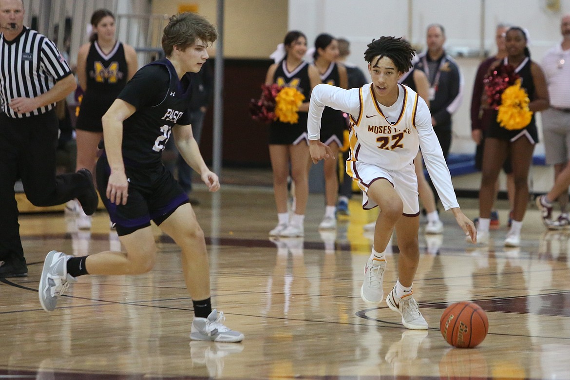 Moses Lake sophomore Tyce Miller (22) dribbles the ball up the court against Pasco.