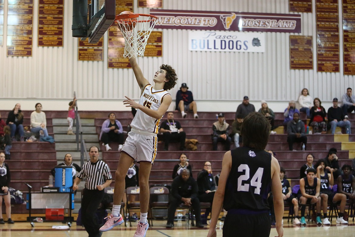 Moses Lake sophomore Grady Walker (15) lays the ball in for a basket in the first quarter against Pasco.