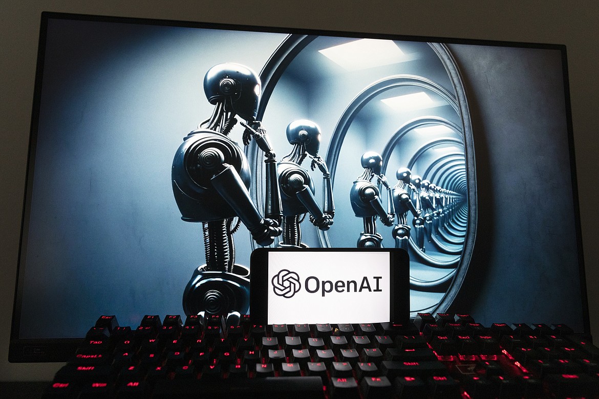 The OpenAI logo is seen displayed on a cell phone with an image on a computer screen generated by ChatGPT's Dall-E text-to-image model, Friday, Dec. 8, 2023, in Boston. Artificial intelligence went mainstream in 2023 — it was a long time coming and has a long way to go for the technology to match people's science fiction fantasies of human-like machines. (AP Photo/Michael Dwyer)