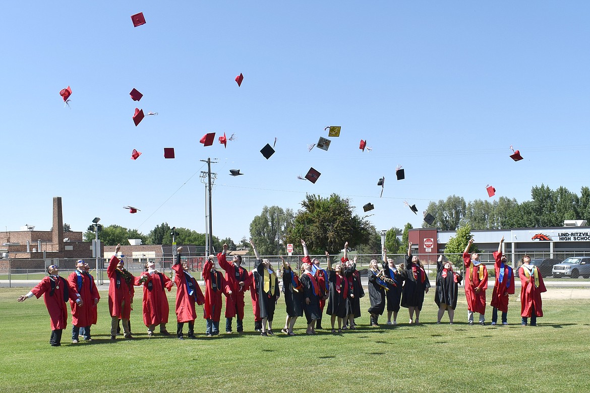 Lind-Ritville High School seniors throw their caps in the air during the school’s graduation ceremony.