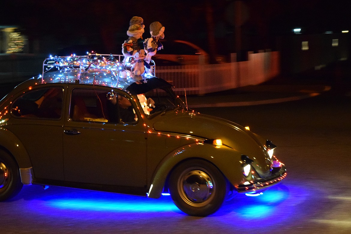 A classic VW Beetle decked out in Christmas lights, including lights under the car, participates in the annual Christmas parade in Mattawa.