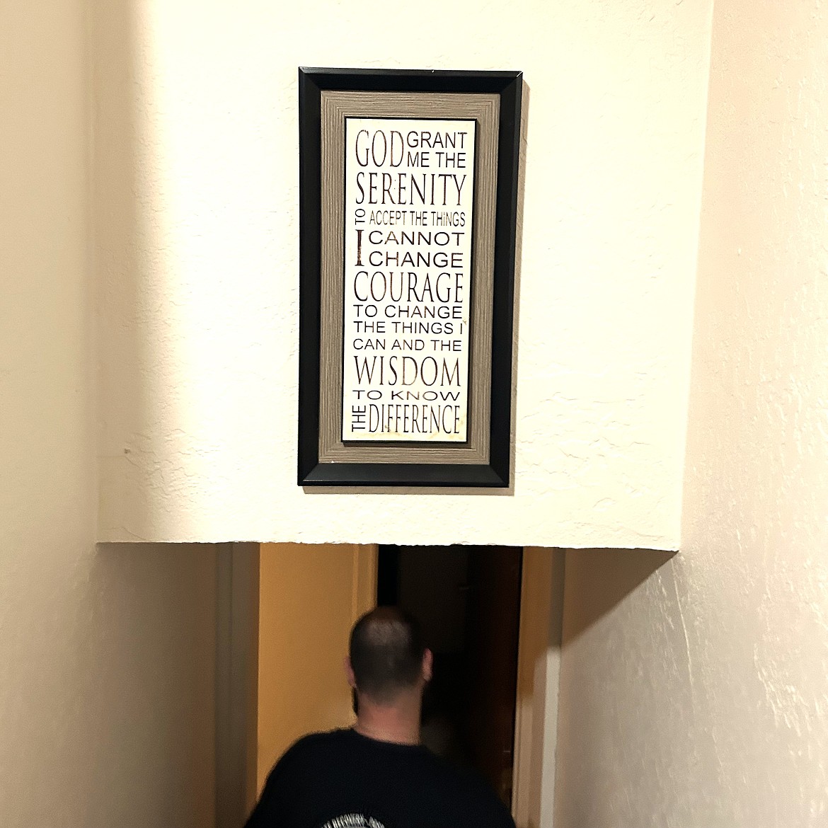 Steve Brummel passes under a Christian message as he walks down the stairs of one of The Way Home CDA units in Coeur d'Alene.