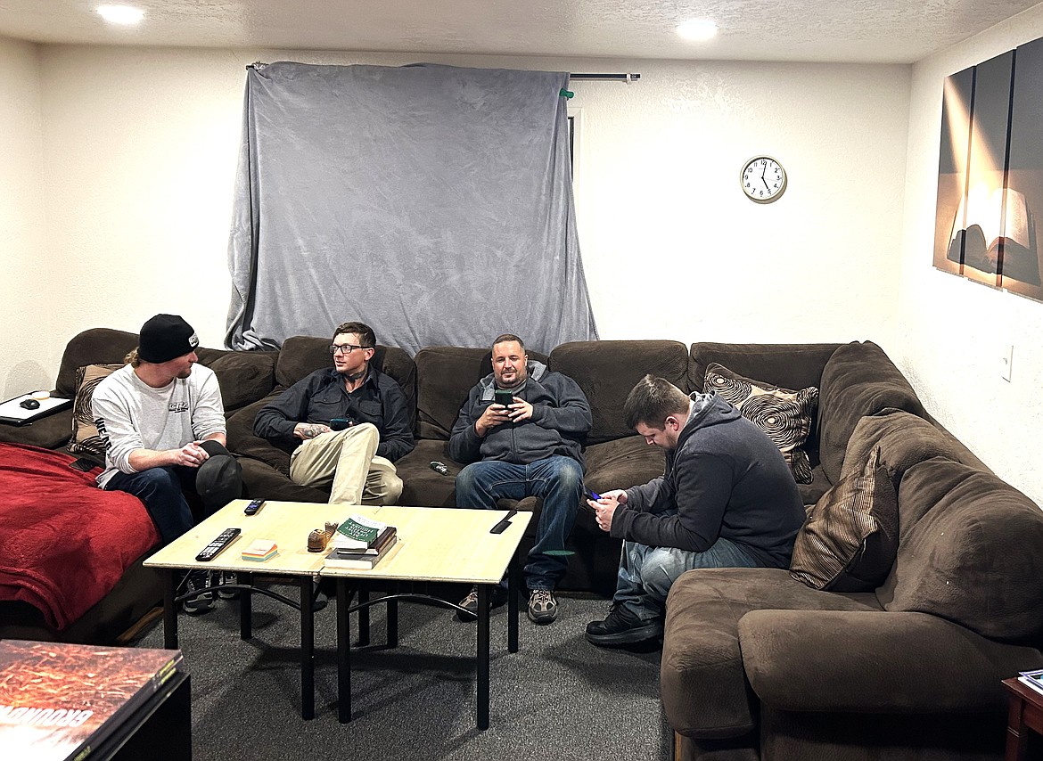 Men with The Way Home CDA chat and check their phones at one of the Coeur d'Alene homes. From left, Mitchell Davis, Doug Gordon, Clayton Tucker and Shad Campbell.