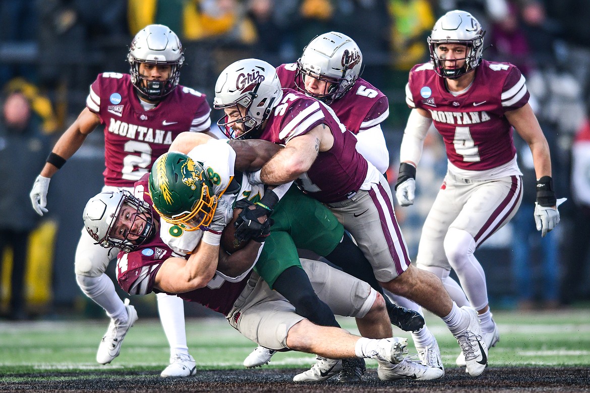 Grizzlies linebackers Tyler Flink (54) and Levi Janacaro (37) bring down North Dakota State running back Barika Kpeenu (8) in the second quarter of an FCS semifinal game at Washington-Grizzly Stadium on Saturday, Dec. 16. (Casey Kreider/Daily Inter Lake)