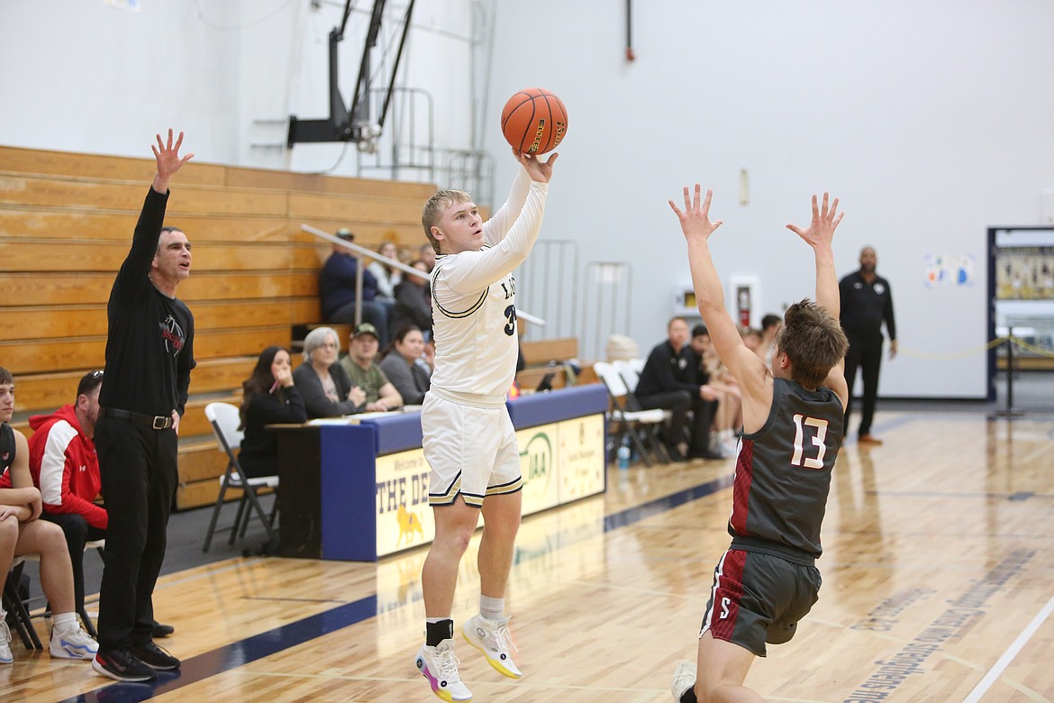 MLCA/CCS senior Jonah Robertson (34) attempts a three-pointer in the first half against Waterville-Mansfield on Friday. Robertson led the Lions with 11 points in the win.