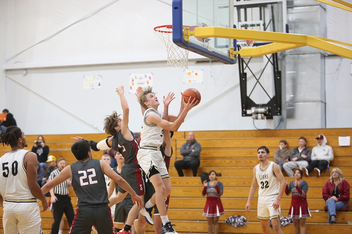 MLCA/CCS sophomore Johnny Ferguson, holding the ball, leaps up while attempting a layup.