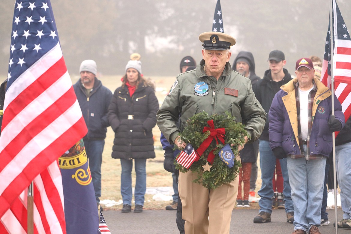 Chief Petty Officer Dennis Fox carries a remembrance wreath at Coeur d'Alene Memorial Gardens on Saturday in memory of those who served and are serving in the Navy.