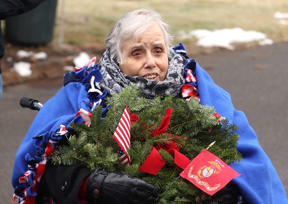 Pat Mitchell holds a wreath at Coeur d'Alene Memorial Gardens on Saturday.