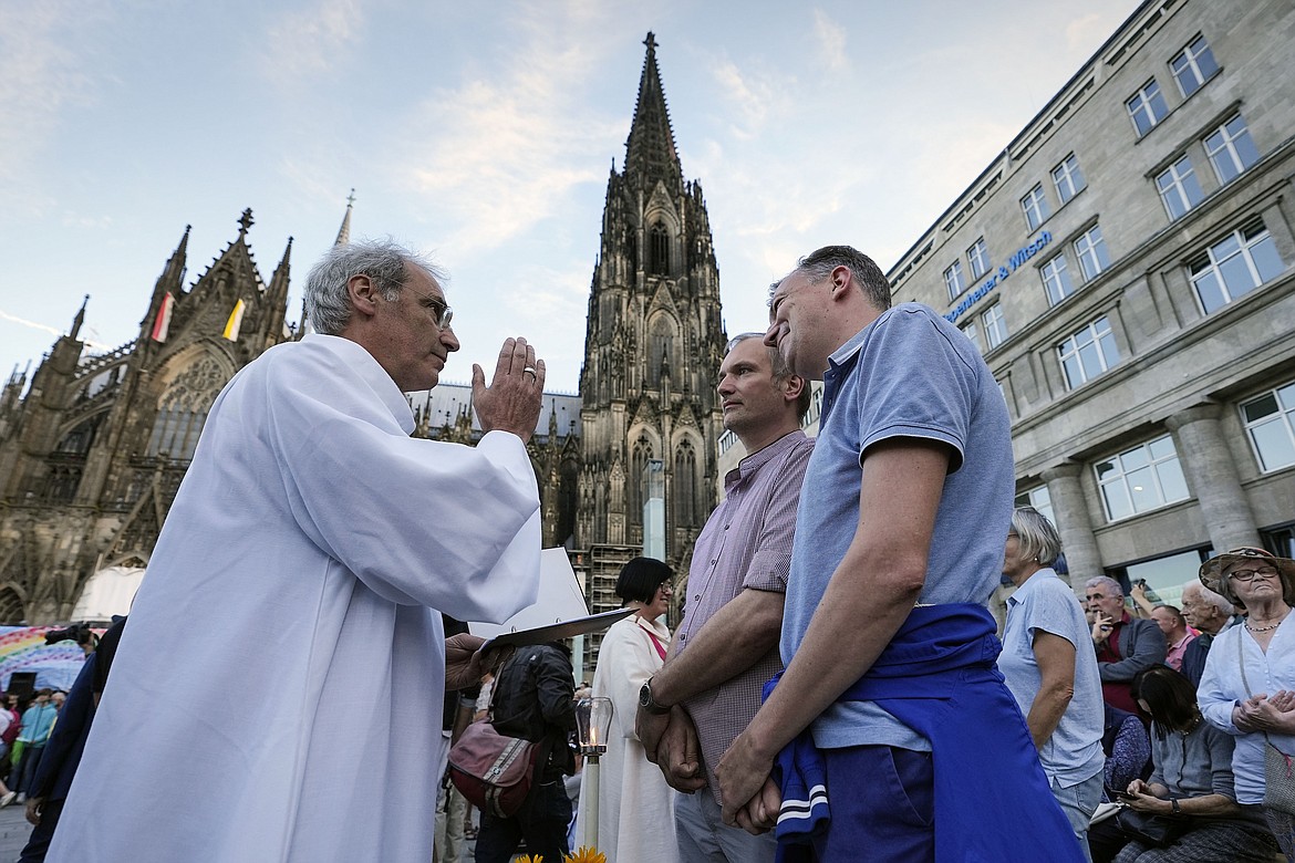 Same-sex couples take part in a public blessing ceremony in front of the Cologne Cathedral in Cologne, Germany, on Sept. 20, 2023. Pope Francis has formally approved allowing priests to bless same-sex couples, with a new document released Monday Dec. 18, 2023 explaining a radical change in Vatican policy by insisting that people seeking God’s love and mercy shouldn’t be subject to “an exhaustive moral analysis” to receive it. (AP Photo/Martin Meissner, File)