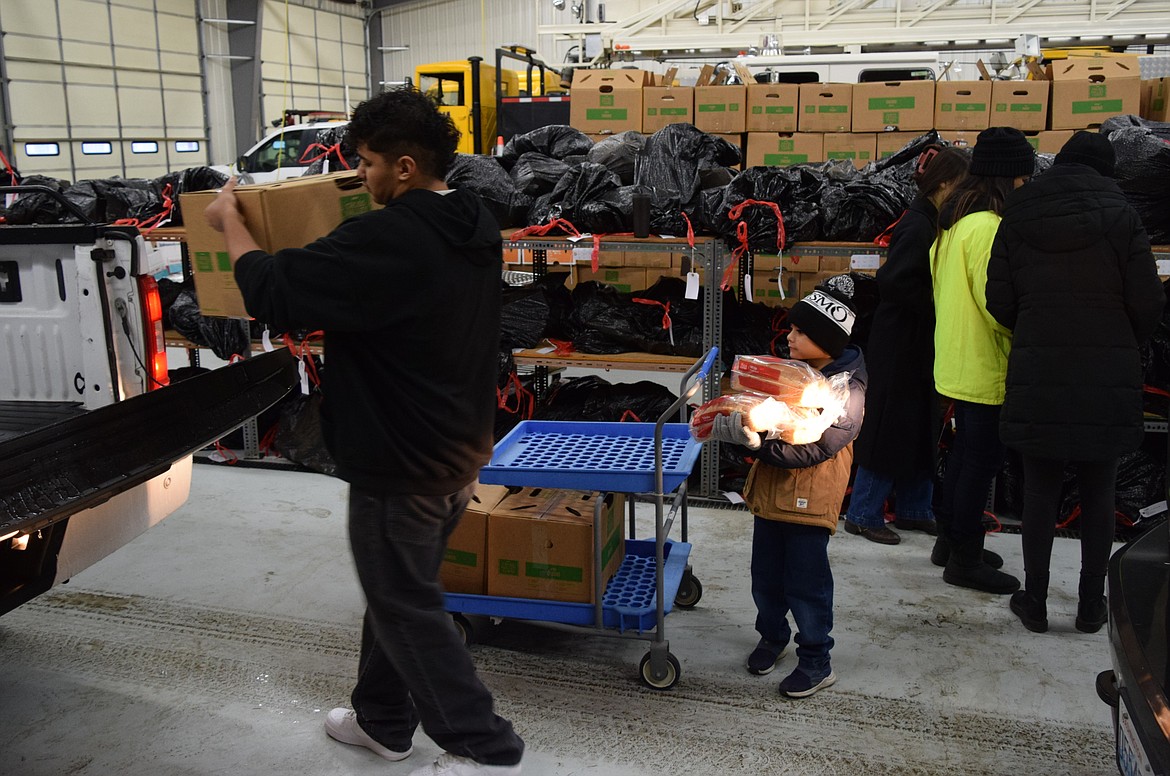 Youth volunteers help load a volunteer delivery truck Saturday with Christmas baskets – or boxes – and food to help families in need during the holiday season as part of the annual Othello Community Christmas Baskets program.