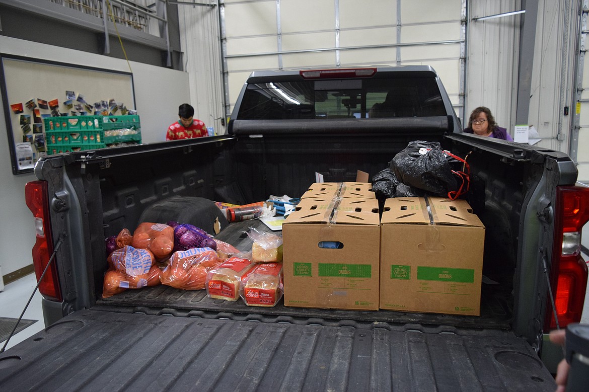 Christmas baskets and food are loaded into a community member’s truck to be delivered to families in need for the holidays for the Othello Community Christmas Basket program.