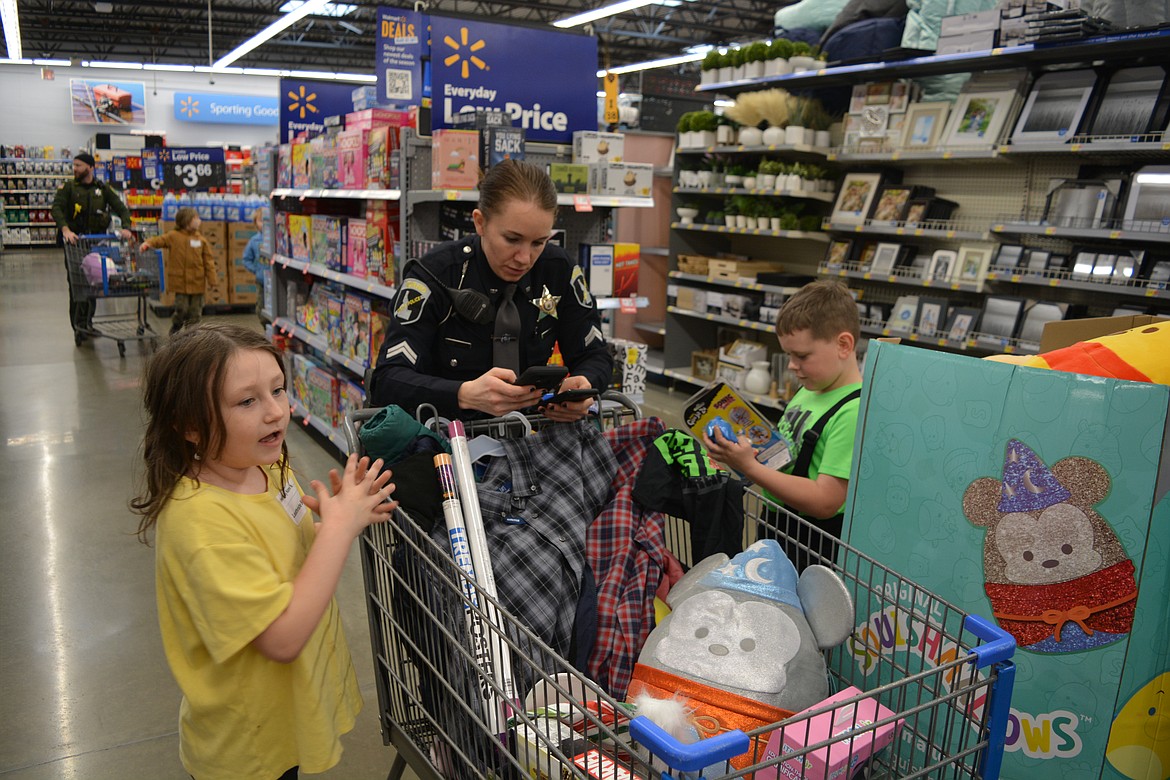 State trooper Kristen Noah crunches the numbers for their shopping budget as she and Leathrishe Bowen and Maddox Walker get ready to head to the register to check out during Shop with a Cop on Dec. 16.