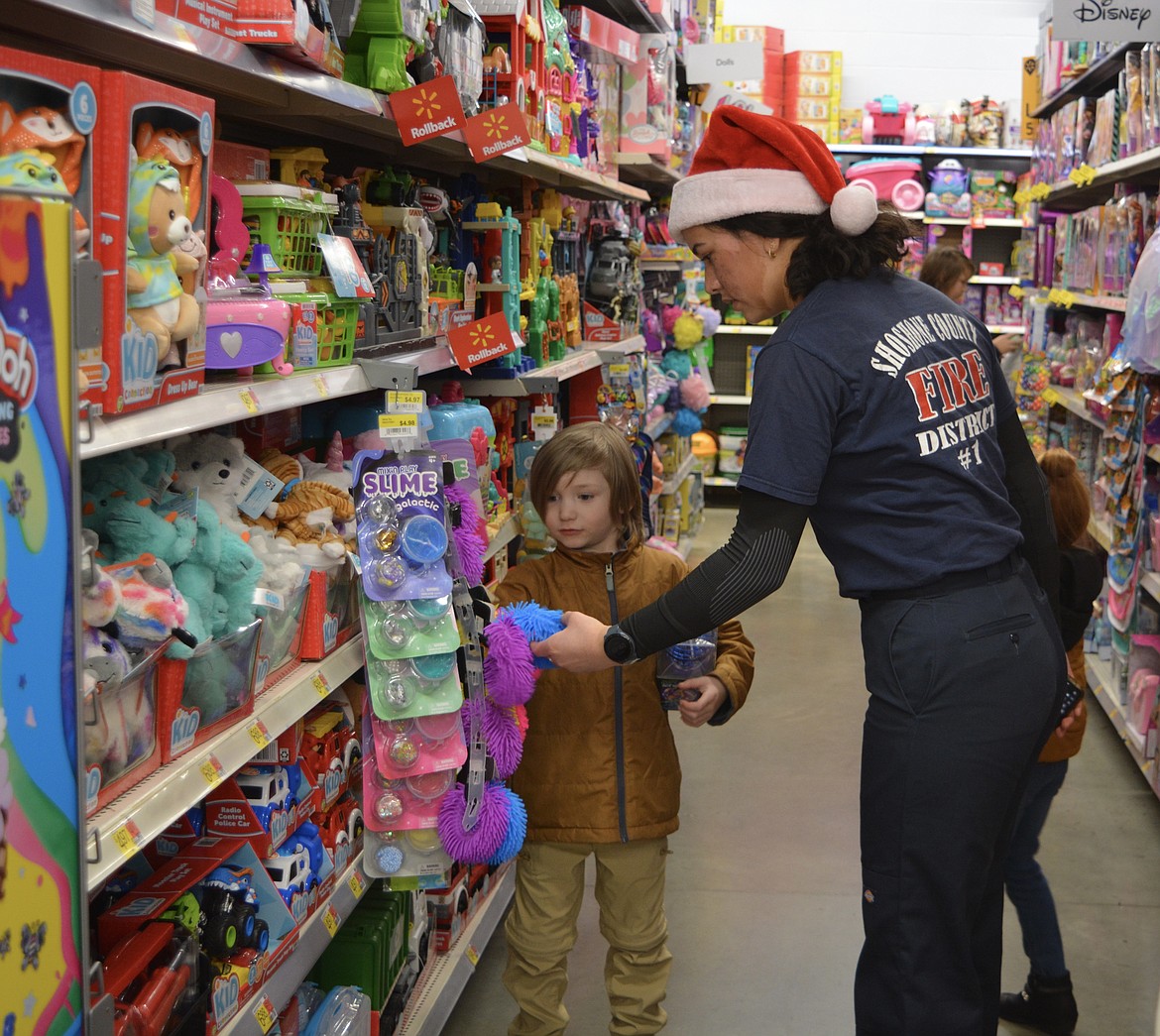 Archer Flatt and Cother La’a of Shoshone Fire District No. 1 go through the final purchases for Shop with a Cop at the Smelterville Walmart.