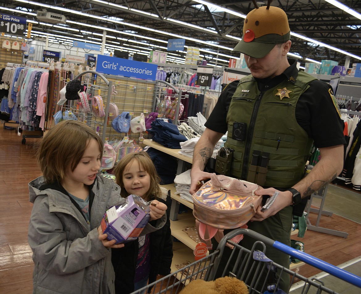 Zoey Northrup and Viada Northrup pick out items at Walmart while an antler-clad Deputy Nathan Shultz tallies up how much remains in their shopping budget.