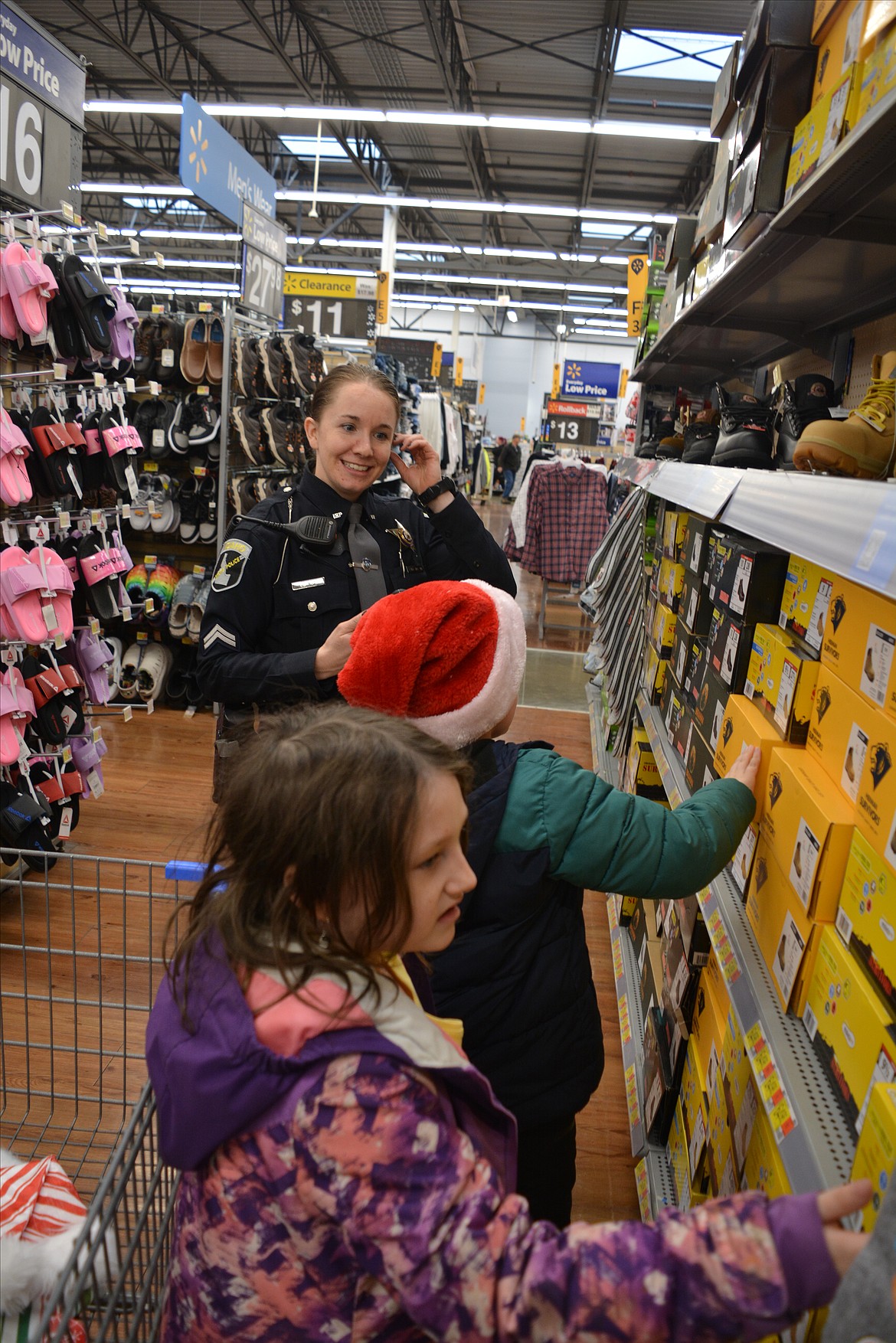 Trooper Kristen Noah helps Maddox Walker and Leathrishe Bowen pick out presents for their family members on Dec. 16.