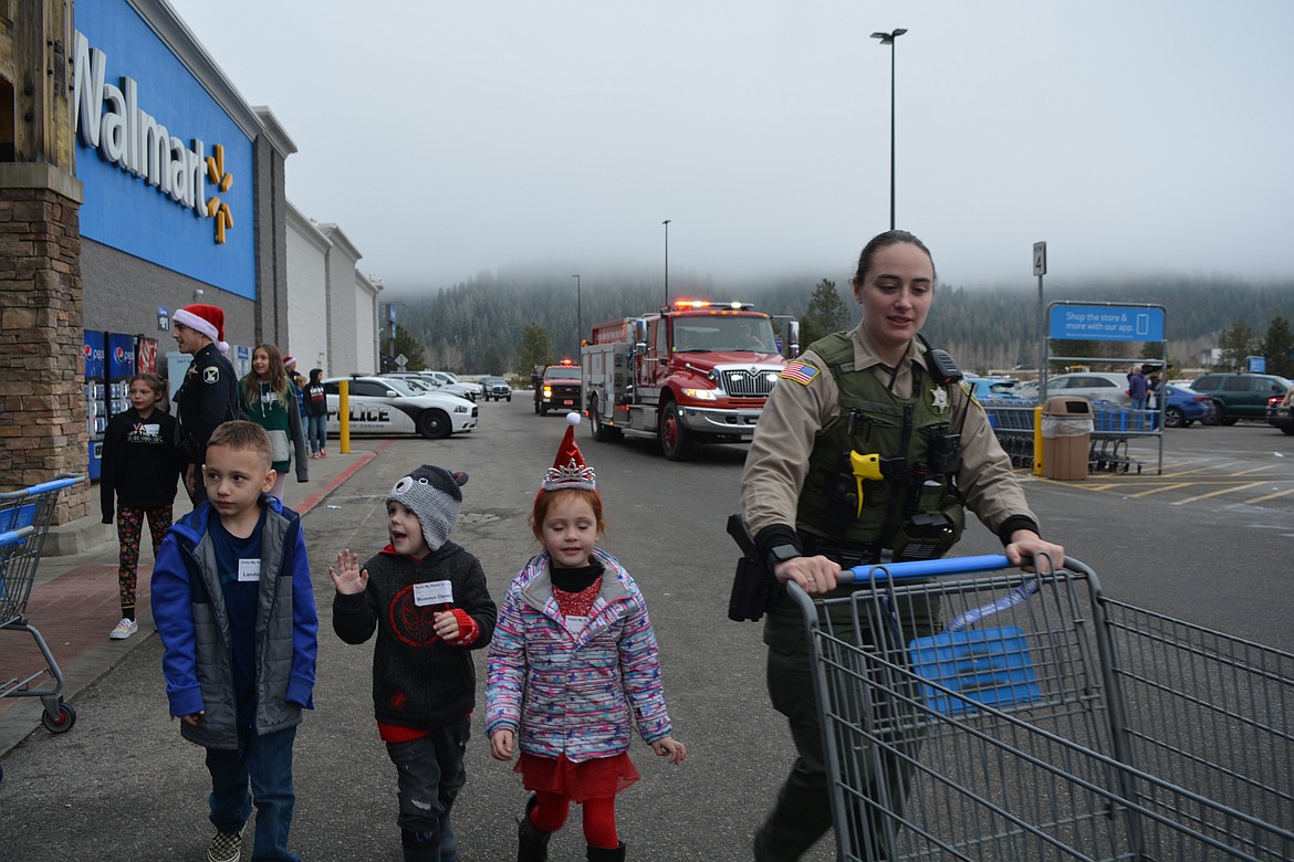 Maximus, Landon, Paisley, and Deputy Josey Stemrich get ready to go on a kid-led shopping spree during Shop with a Cop in the Silver Valley.