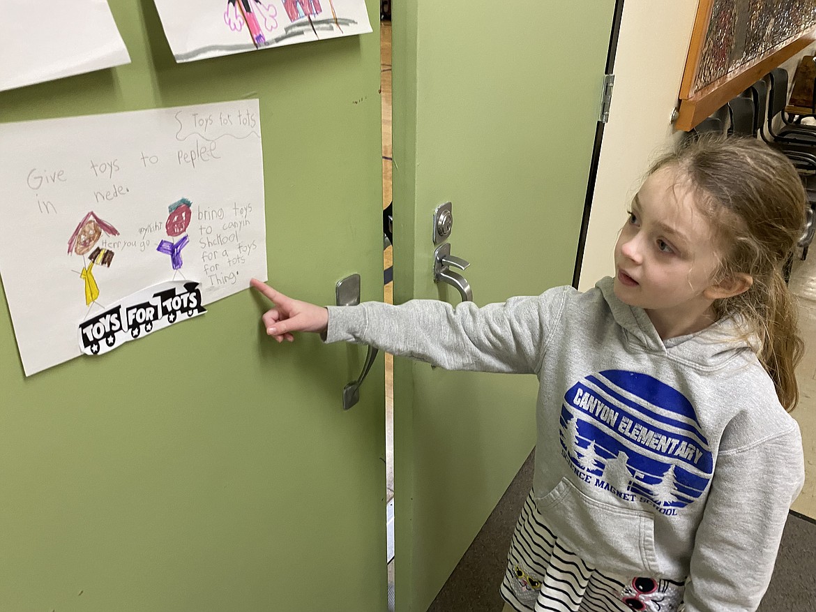 Frankie reads her Toys for Tots poster advertising the toy collection her class took on after reading the children's book "Maddi's Fridge." The book is about learning constructive ways to help while respecting one another in our communities.
