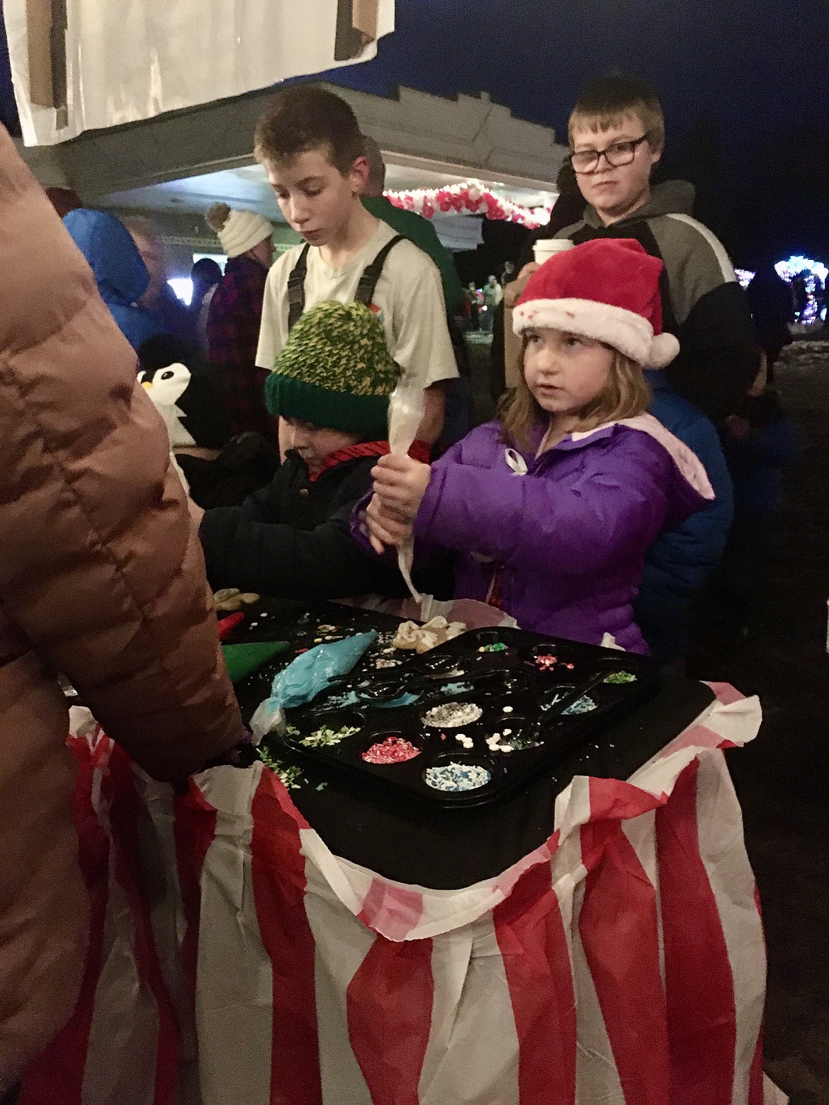 Younger students, William and Eden layer frosting on their cookies, while the bigger kids wait in line for their turn at cookie decorating. (Mineral Independent/Amy Quinlivan)