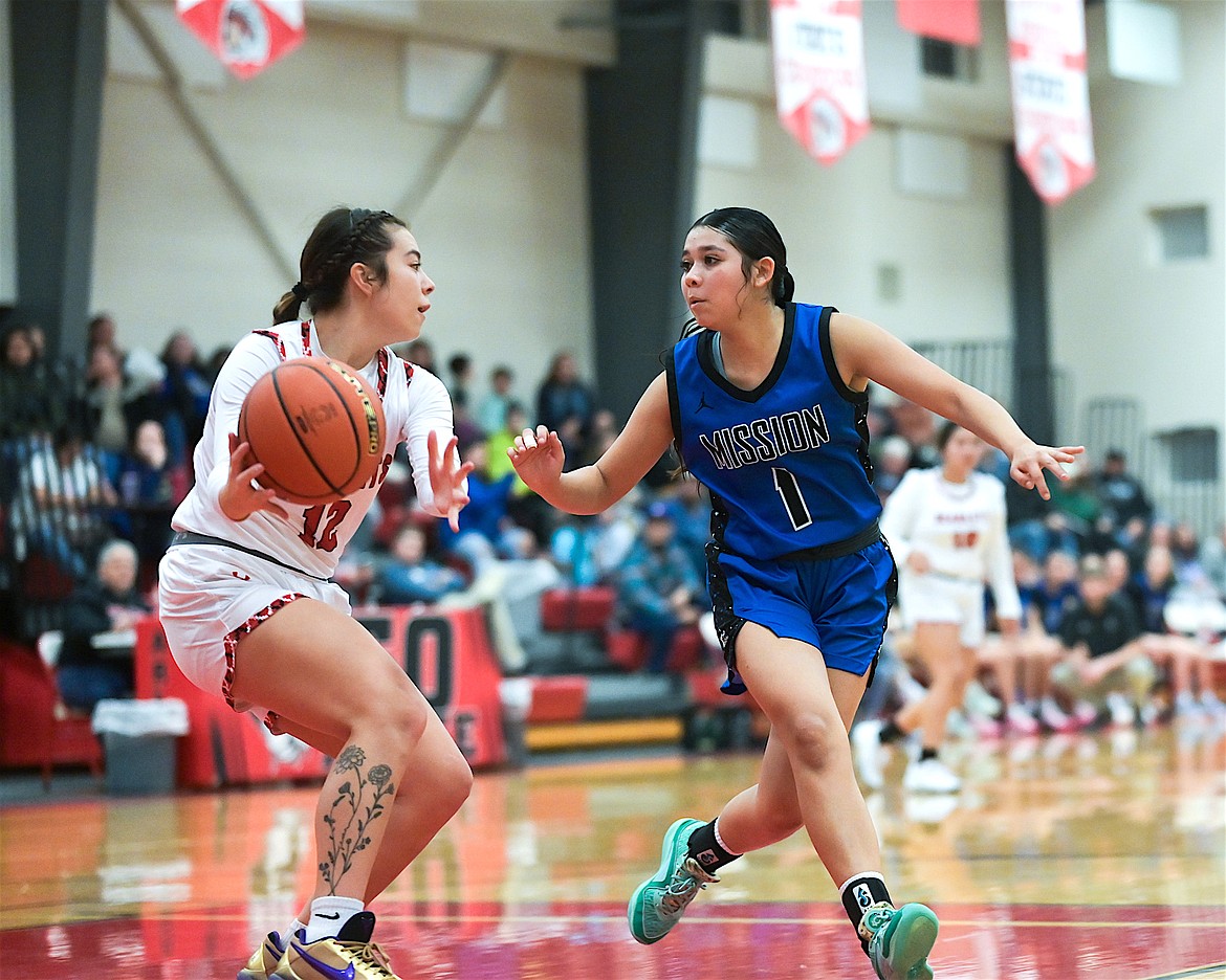 Scarlet Leah Mesteth plays keep-away with Lady Bulldog Kason Page during last week's contest between Mission and Arlee. (Christa Umphrey photo)