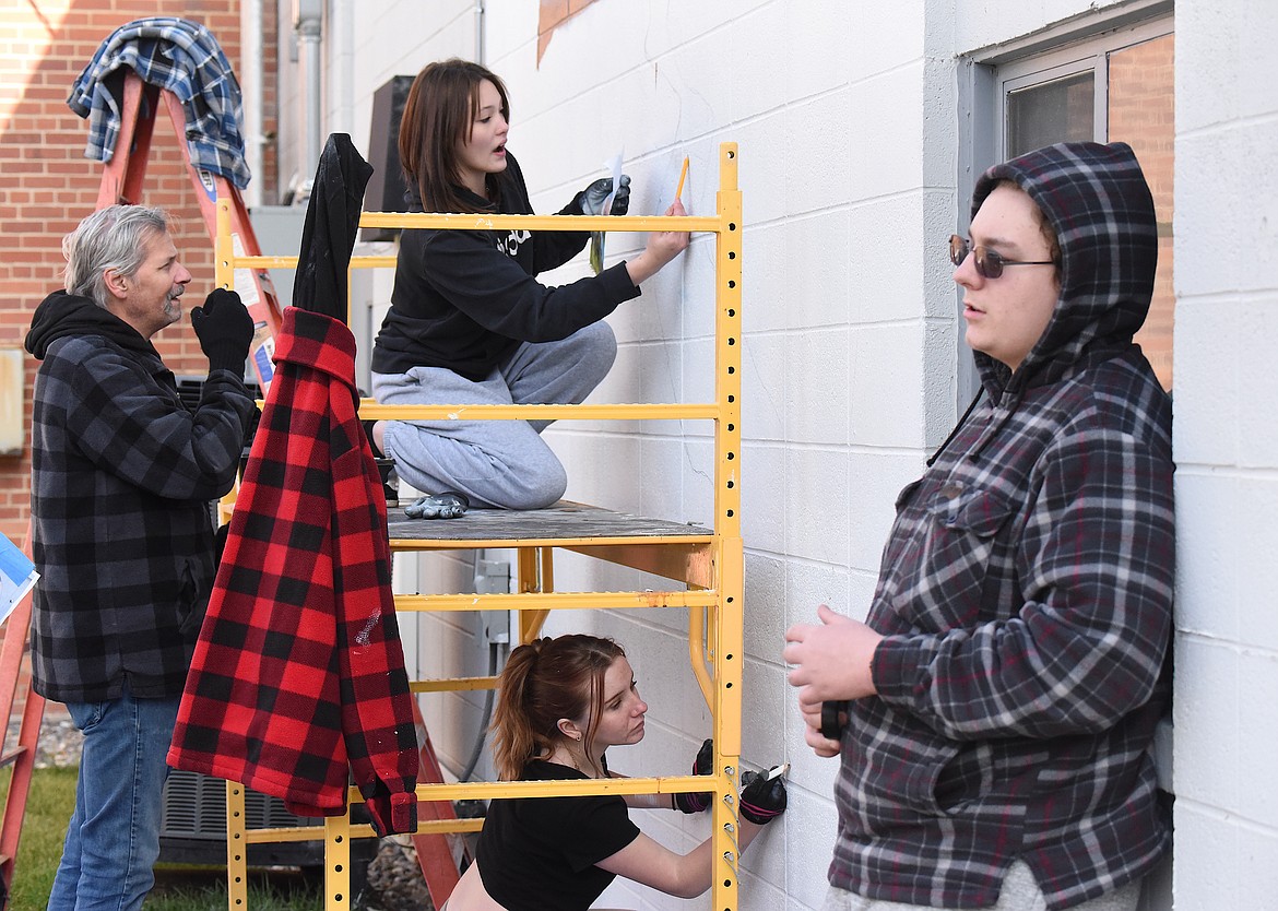 A team of Central School students and teachers worked around difficult weather conditions to paint a mural in Libby’s Peace Officer Park. From left, are teacher Dean Harreid and students Grace Webber, Marcianna McKeever and Alex Barber. (Scott Shindledecker/The Western News)