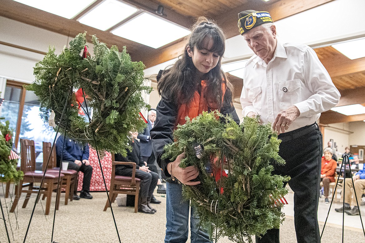 Isabella Aguilar and veteran Gene Brainerd mount a holiday wreath in honor of those who served during the Wreaths Across America event at Montana Veterans Home on Saturday, Dec. 16. (Avery Howe photo)