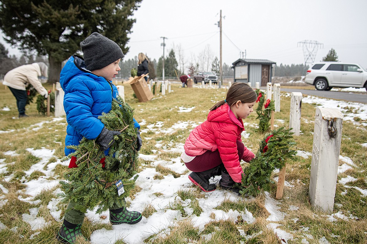 Carter and Madison Kammerzell place wreaths over the graves at Montana Veterans Home Cemetery with the Wreaths Across America program on Saturday, Dec. 16. (Avery Howe photo)