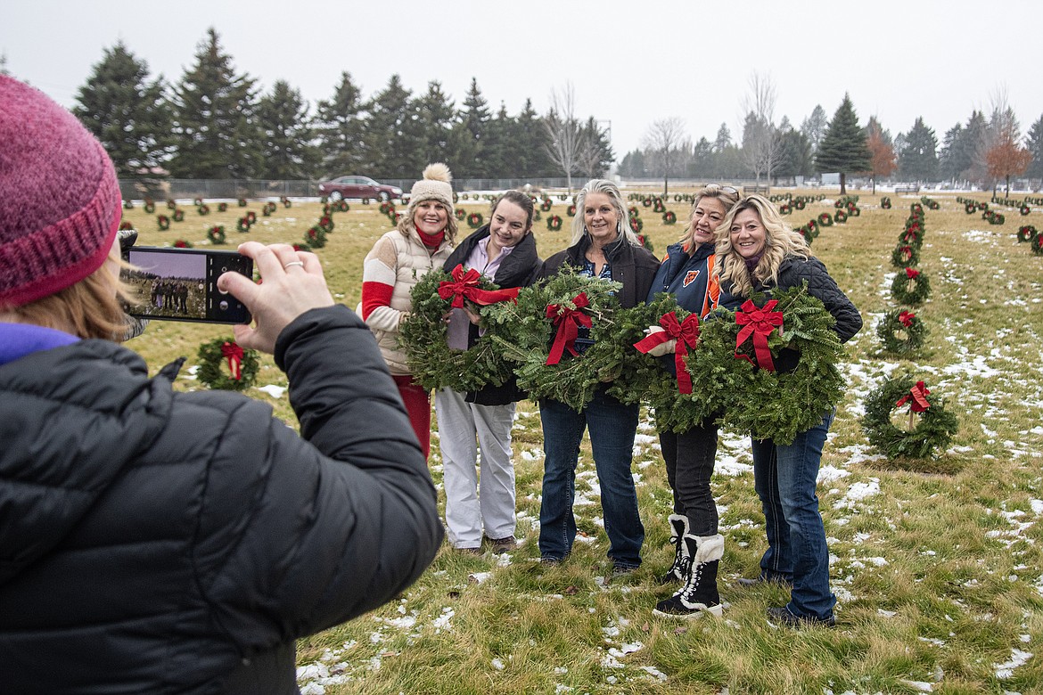 Wreaths Across America volunteers Sonya Ryan Graham, Tammy Winnie, Sherri Carter, Laurie Roberts and Denise Berta Holm pose for a photo after decorating the headstones at Montana Veterans Home Cemetery on Saturday, Dec. 16. (Avery Howe photo)