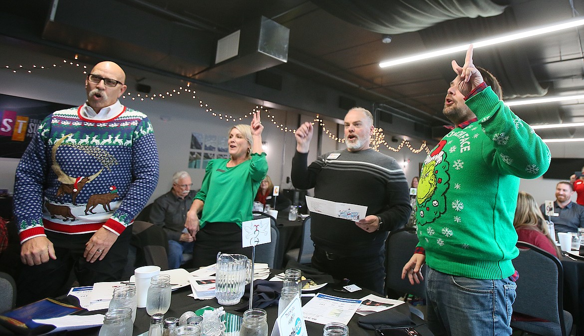 From left, Alan Wolfe, Melissa Schock, Chuck Ethridge and Jeff Rocco contribute their theatrics to the two turtle doves verse during a whole-group singalong of "The 12 Days of Christmas" Tuesday at the Post Falls Chamber's last meeting of the year.