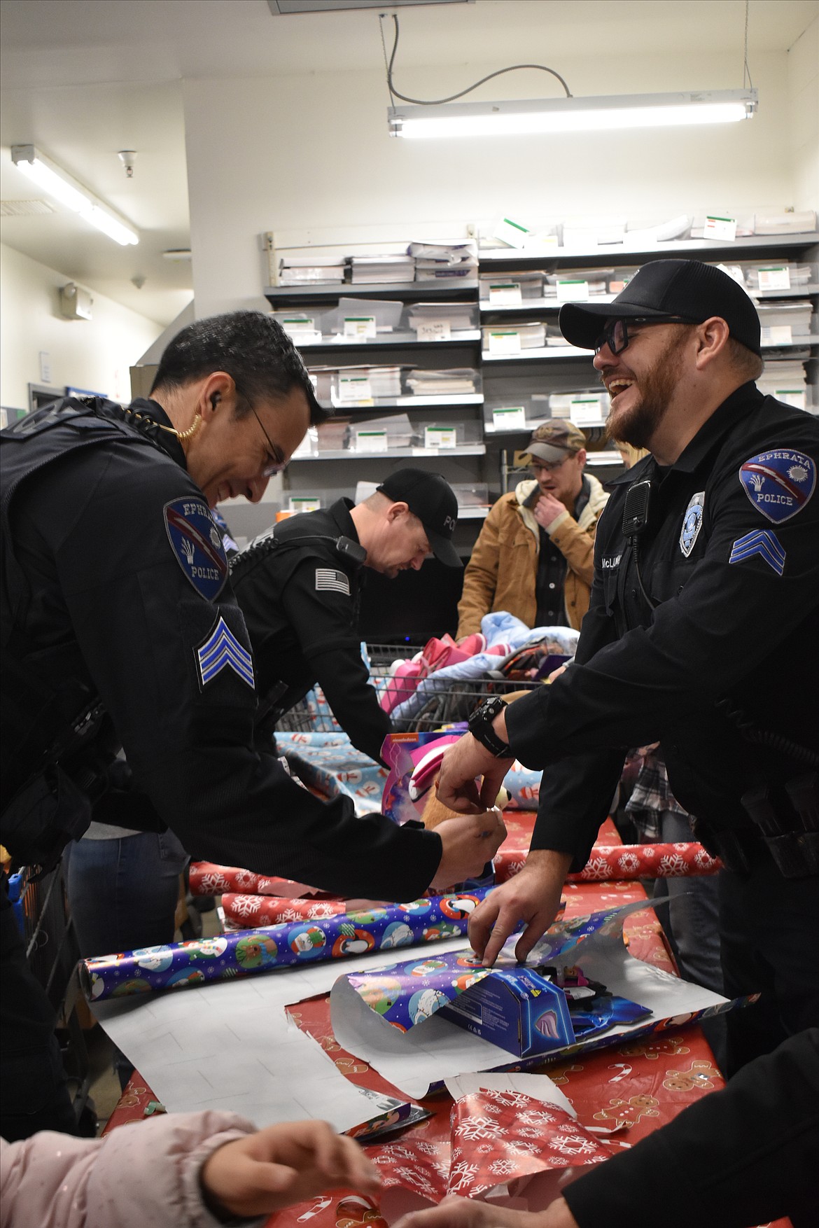 Officers work hard wrapping the gifts just bought during the 2023 combined Ephrata and Soap Lake Shop With a Cop event.