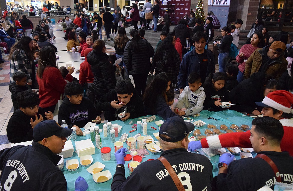 Community members decorate cookies with members of Grant County Fire District 8 during the Dec. 14 Mattawa Winter Festival.