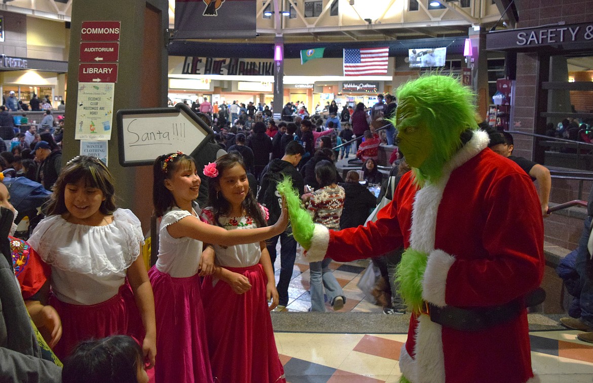 The Grinch high-fives a youth dancer during the 2023 Mattawa Winter Festival held at Wahluke High School Dec. 14.