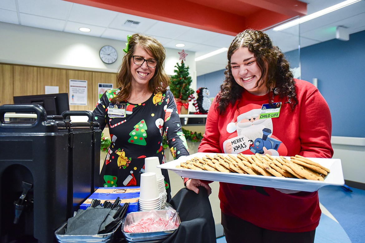 Logan Health Children's Child Life Specialists Amy Rohyans Stewart and Tia Beck deliver cocoa and cookies during the hospital's Cookies and Cocoa with Santa event on Wednesday, Dec. 20. (Casey Kreider/Daily Inter Lake)