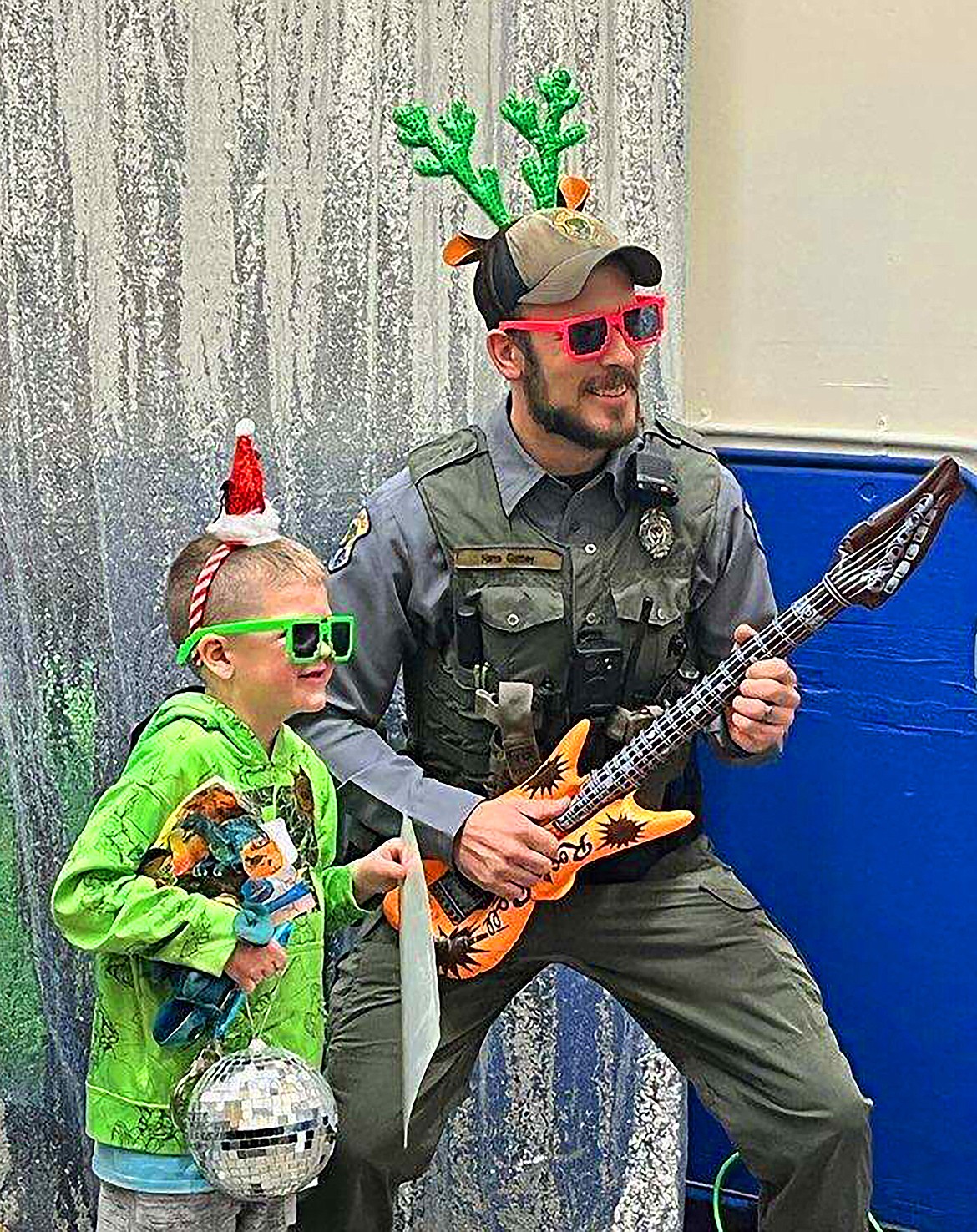 A local youth is pictured having fun mugging for the camera at the photo booth along with a local law enforcement officer during the recent "Shop With a Cop" event.