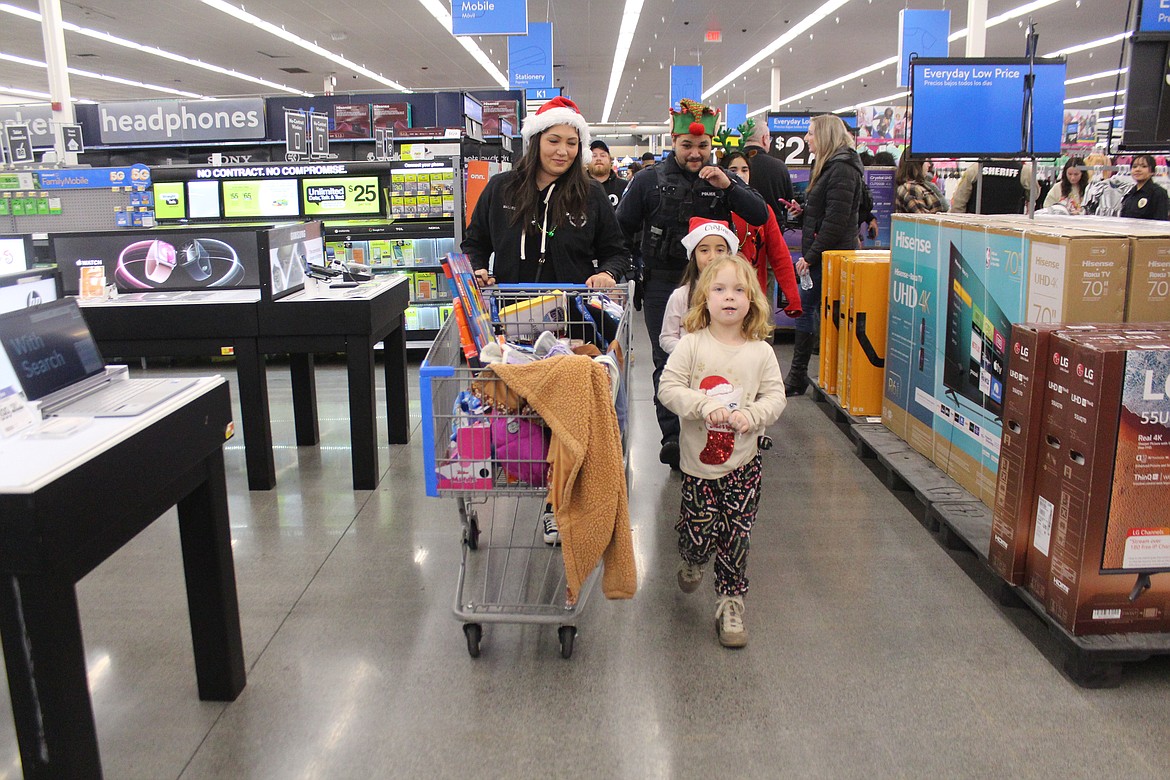 The shopping done and the cart loaded, Moses Lake Police Department personnel and their shopping buddies head toward the checkout.