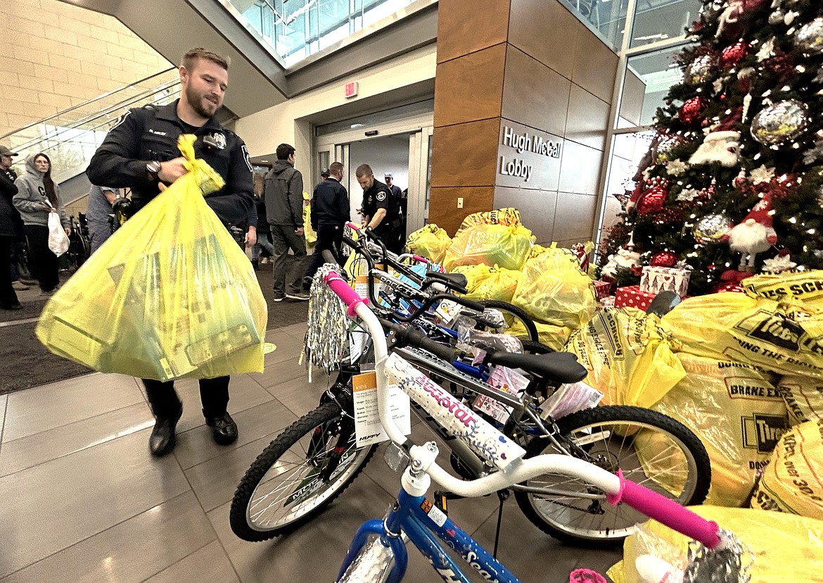 Coeur d'Alene Police Detective Dan Haley carries a bag of toys into Kootenai Health on Wednesday.