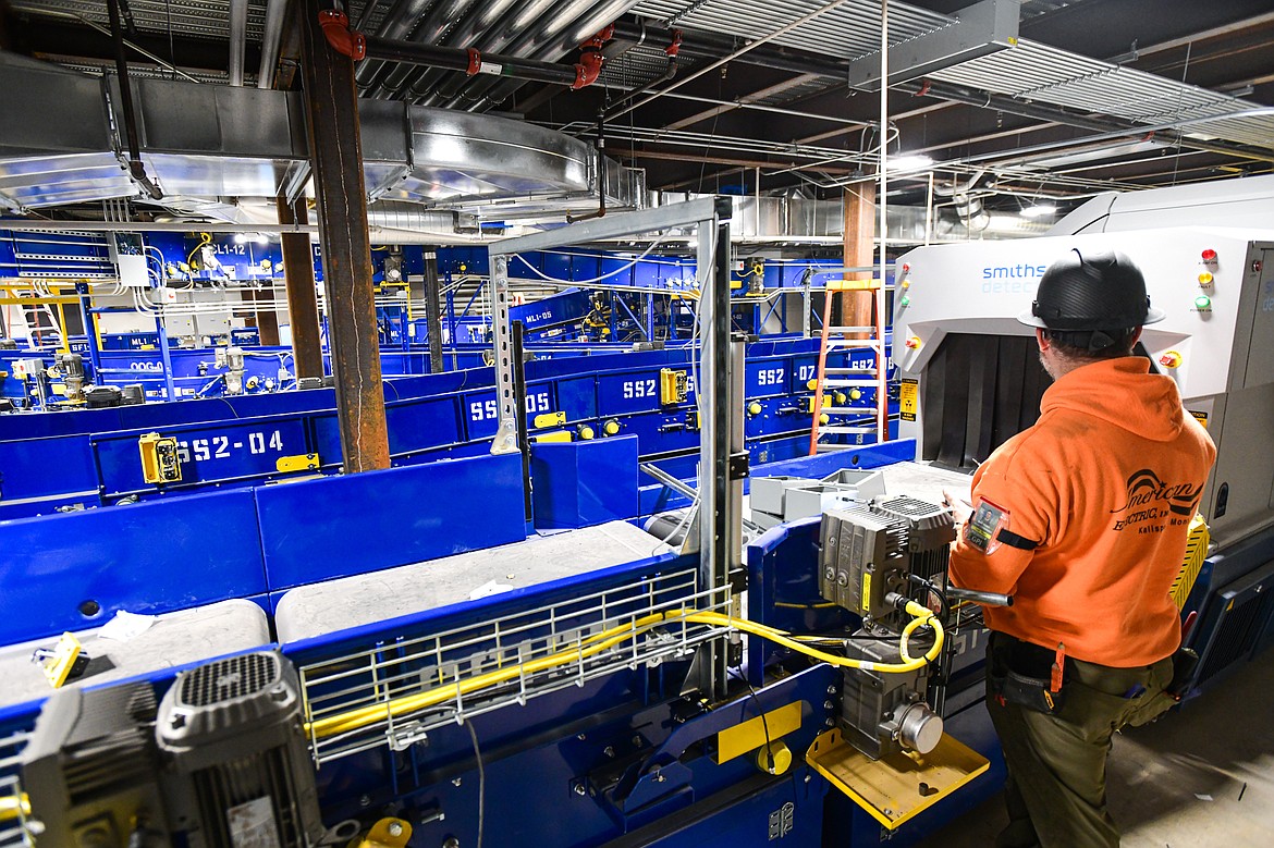 A worker stands at one of the baggage scanners in Glacier Park International Airport's fully-automated baggage handling system, being installed as part of the airport's Expansion Project on Thursday, Dec. 21. (Casey Kreider/Daily Inter Lake)