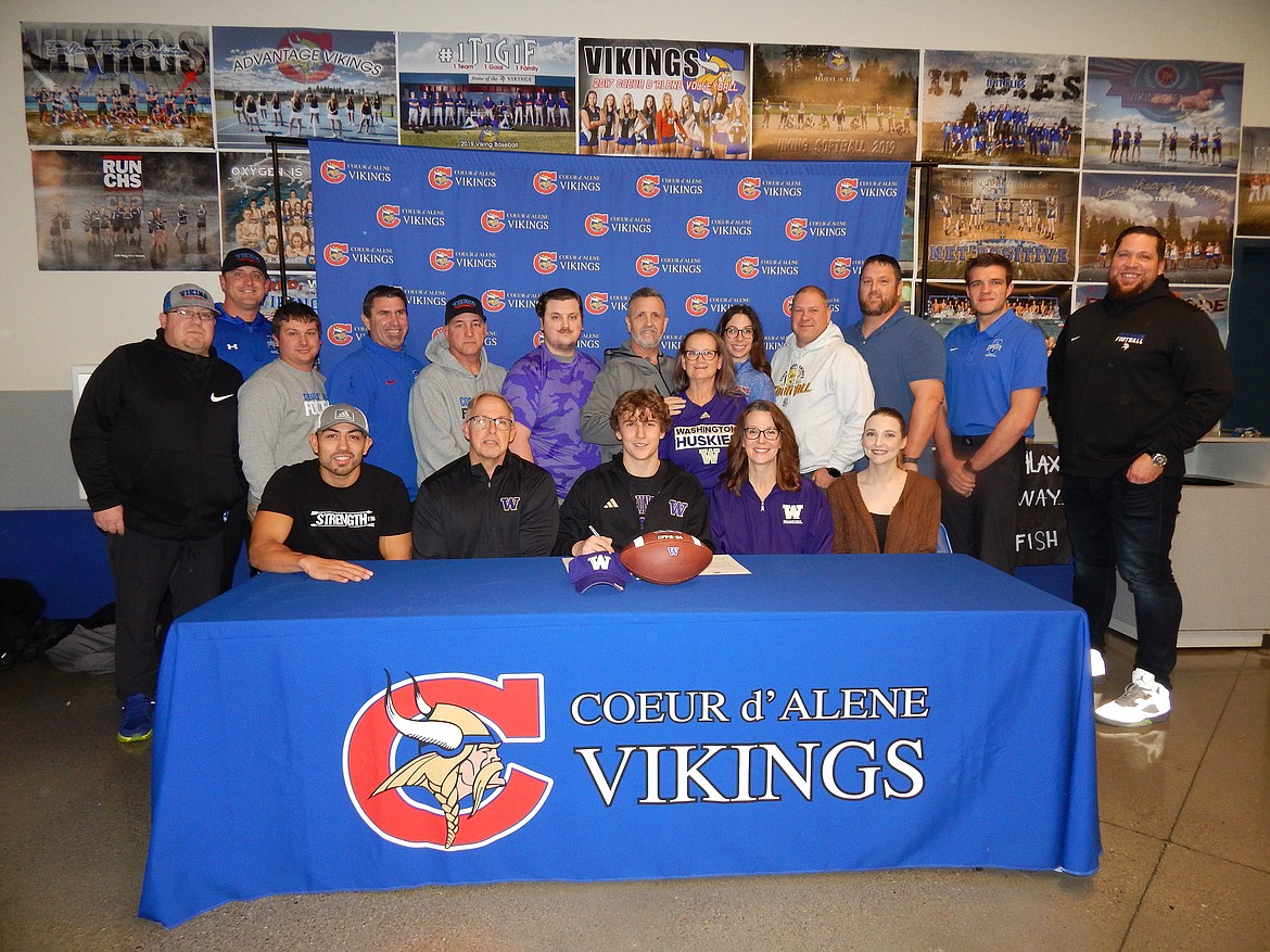 Courtesy photo
Coeur d'Alene High senior Jace Eastlick recently accepted a preferred walk-on offer to play football at the University of Washington. Seated from left are Chris Buskirk (strength coach), James Eastlick (dad), Jace Eastlick, Stacie Eastlick (mom) and Jordyn Eastlick (sister); and standing from left, Brad Richmond, Coeur d'Alene High assistant football coach; Corey Comstock, Coeur d'Alene High assistant football coach; Vinny Lupinacci, Coeur d'Alene High assistant football coach; Dustin Shafer, Coeur d'Alene High assistant football coach; Shawn Amos, Coeur d'Alene High head football coach; Kellan Dyer, Joe Dyer and Lisa Dyer, family friends; Victoria Beecher, Coeur d'Alene High athletic director; Brian Holgate, Coeur d'Alene High assistant football coach; Corey Brown, Coeur d'Alene High assistant football coach; Dylan Franks, Coeur d'Alene High assistant football coach; and Colin Donovan, Coeur d'Alene assistant football coach.