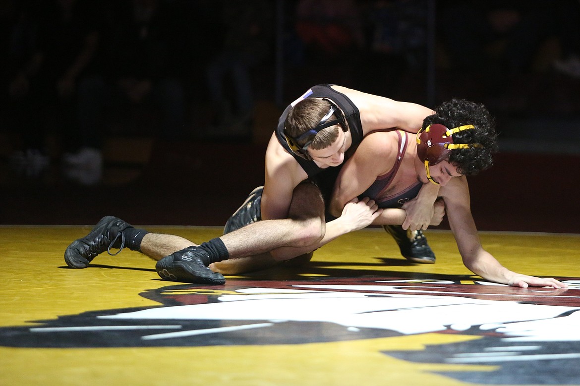 Othello sophomore Mason Russell, top, holds a tight grasp of his opponent, Moses Lake junior Cruz Hernandez during Wednesday’s dual in Moses Lake.