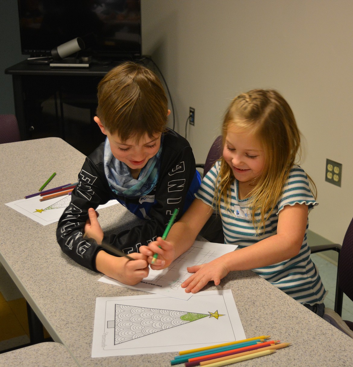 Miles and Pierlee share a coloring project while spreading some Christmas cheer at Shoshone Medical Center. The visit started off with the kids presenting beaded ornaments they made to staff and patients in the cafeteria. Any students with extra ornaments gave them to hospital staff to be gifts to patients who weren't mobile enough to join them for a visit.