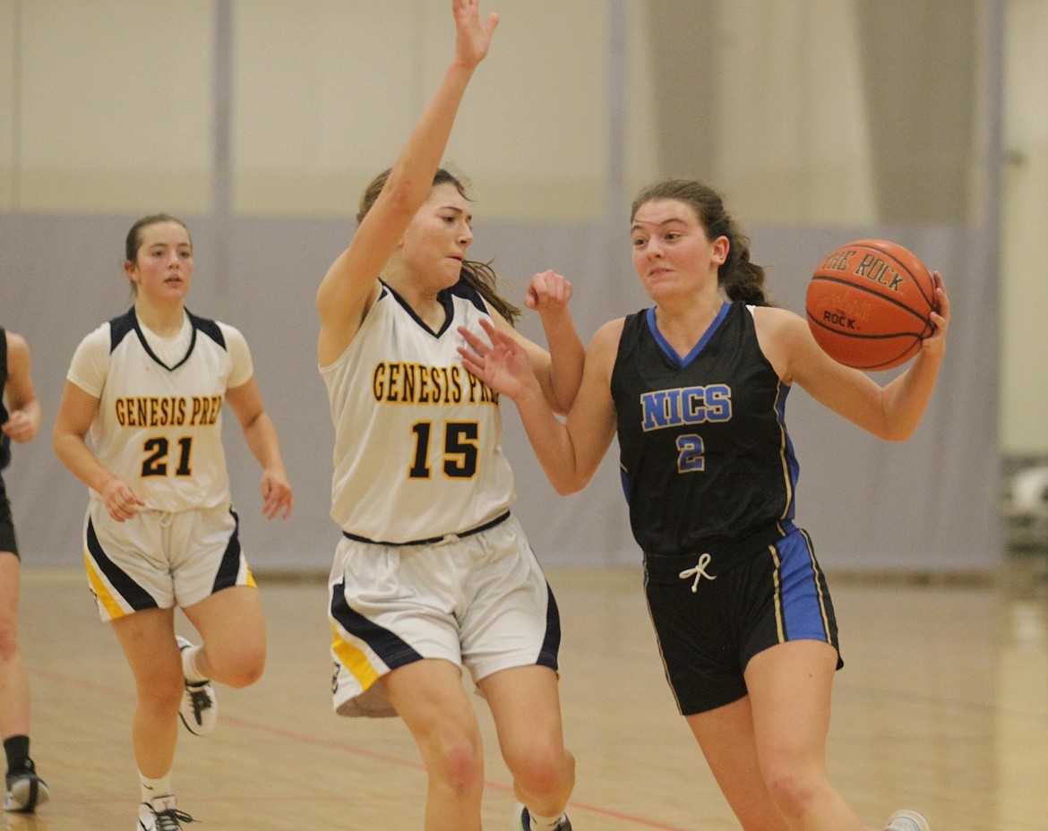 MARK NELKE/Press
Jennifer Peterson (2) of North Idaho Christian School drives to the basket as Summer Nelke (15) of Genesis Prep Academy defends on Friday night at The Courts at Real Life in Post Falls.