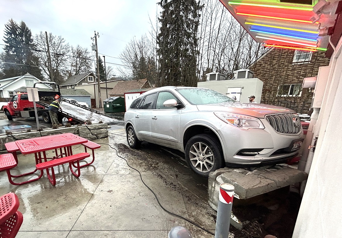 A driver with Schaffer's Towing prepares to remove an SUV from the back of Roger's Ice Cream and Burgers on 12th and Sherman Avenue on Friday afternoon. The driver accidently hit the gas pedal instead of the brake, crashing through a rockery, but stopping just short of the building. No injuries were reported.